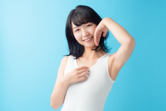 顔に手を当てポーズをとる女性